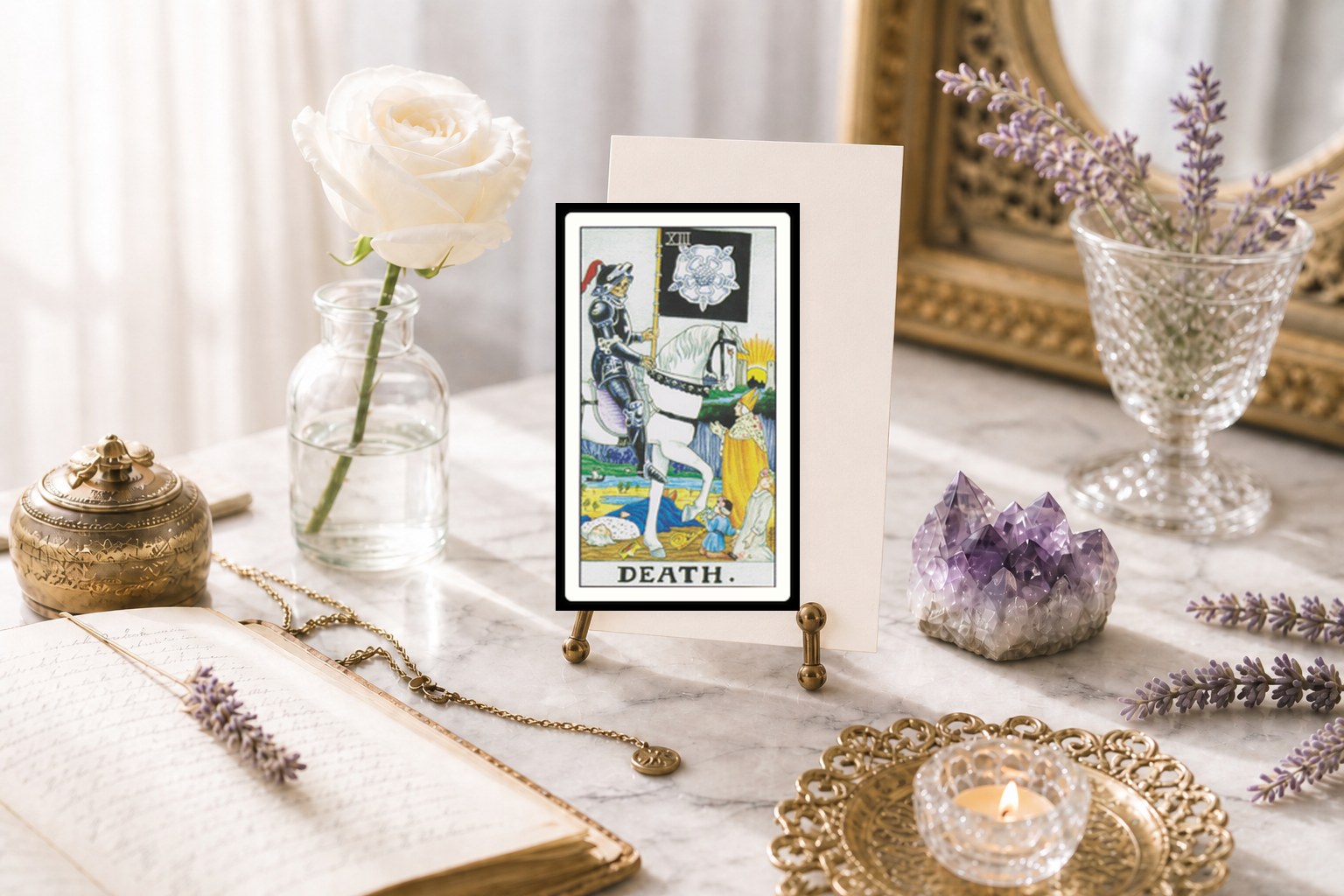 The Death tarot card upright on a brass stand on white marble, with a white rose, amethyst, lavender, open journal, and a lit tea light.