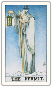 The Hermit tarot card: an elder in a cloak holds a lantern on a mountain path.