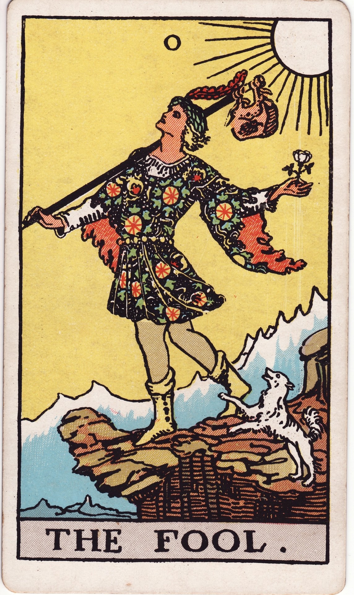 The Fool card from the Rider-Waite-Smith tarot: a youth walks toward a cliff edge with a white rose, a small pack, and a dog at their heels.
